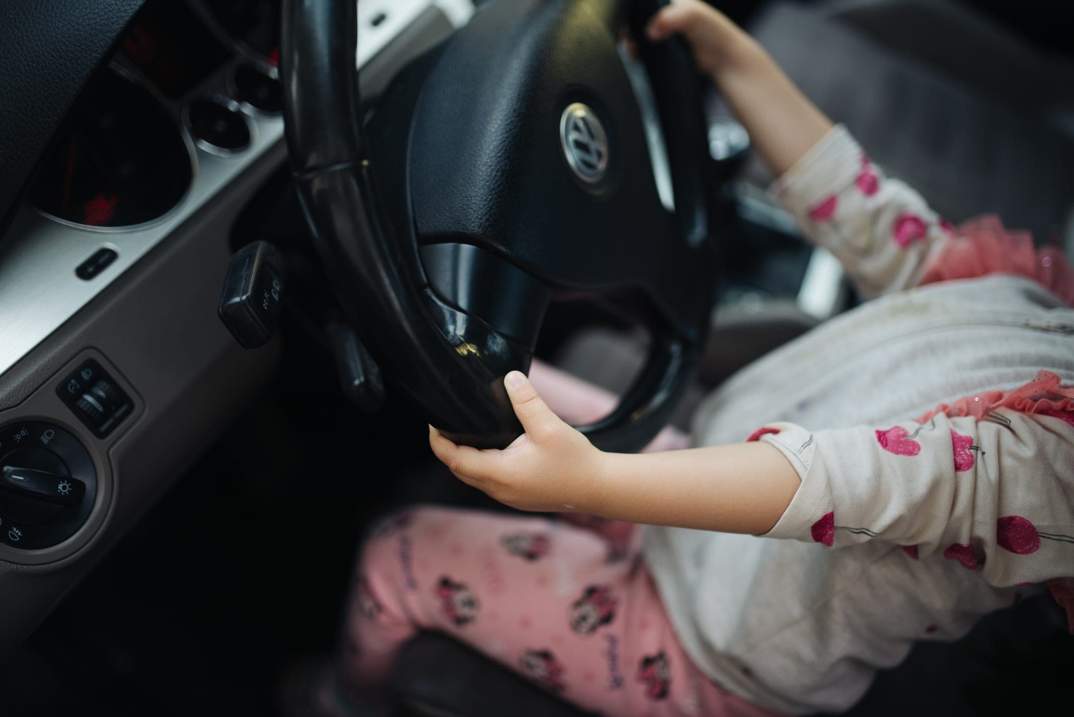 Manos de un niño sobre el volante de un auto