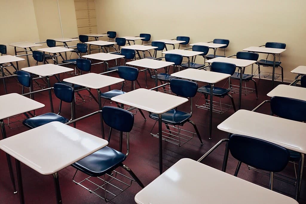 Salón de clases vacío con pupitres en filas